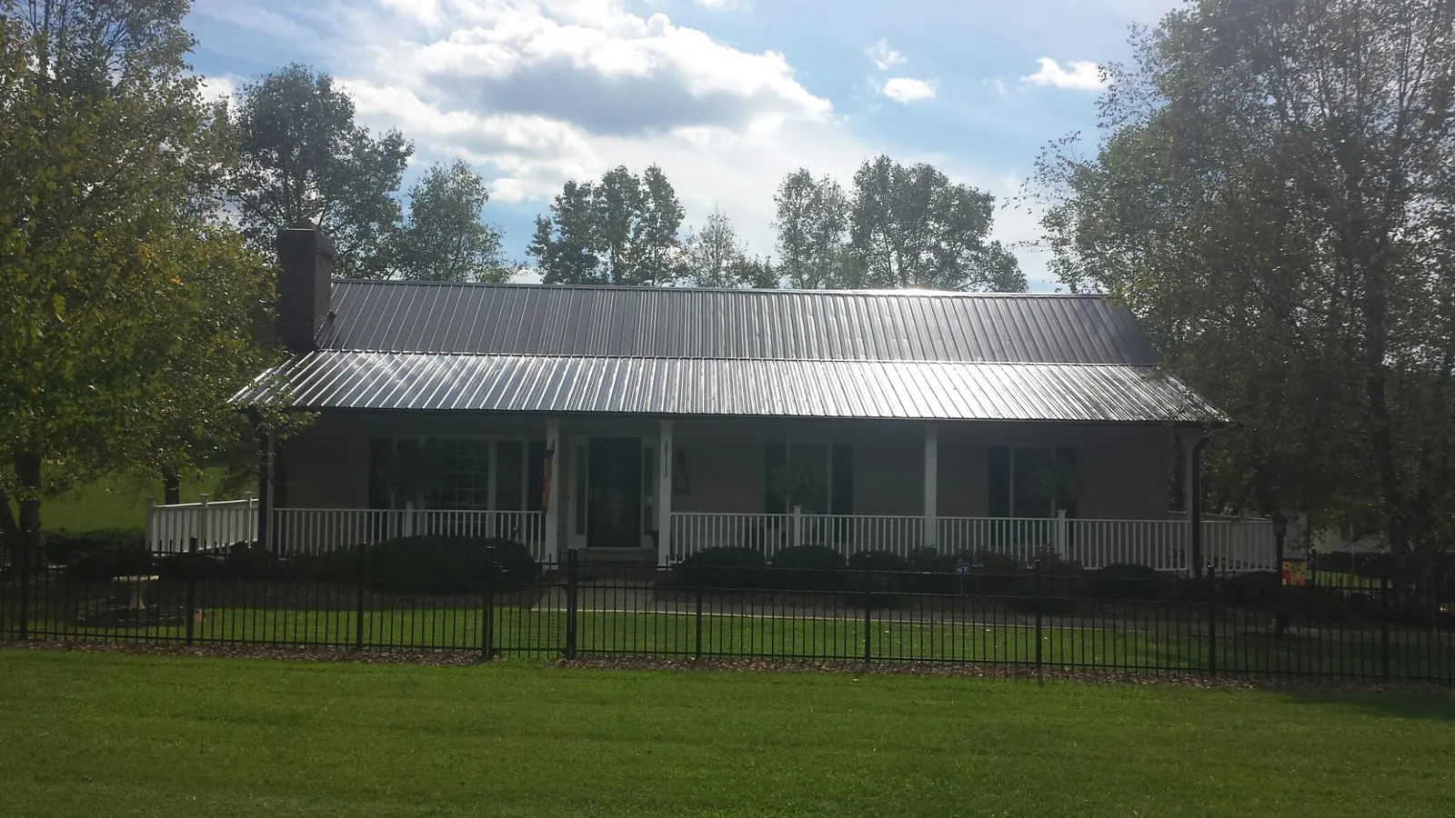 Gray metal roof on a brick ranch with a full width front porch — Gutter Guard Installation work by our crew in Trabuco Canyon